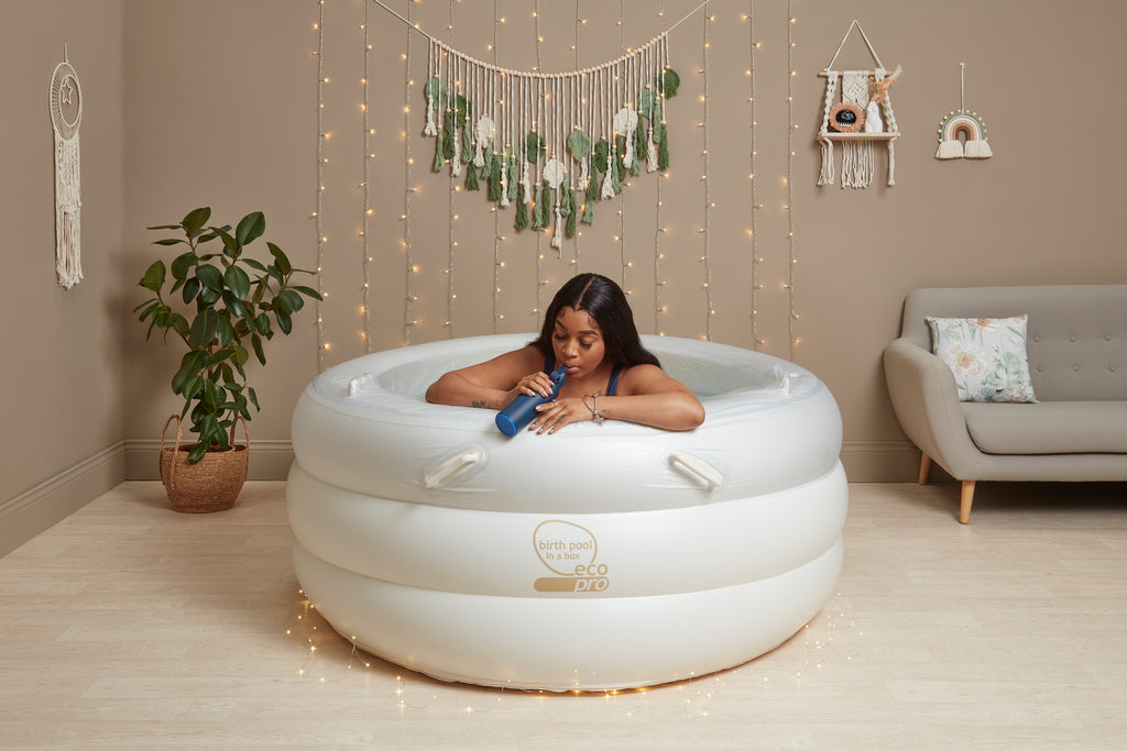 Inflatable birthing pool with internal handles for support during labor