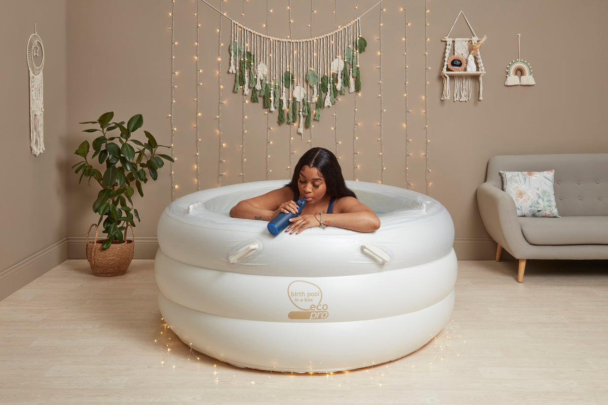 Inflatable birthing pool with internal handles for support during labor